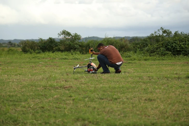 a man kneeling down next to a bike on a field