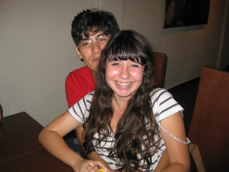 two people pose for a picture at a restaurant