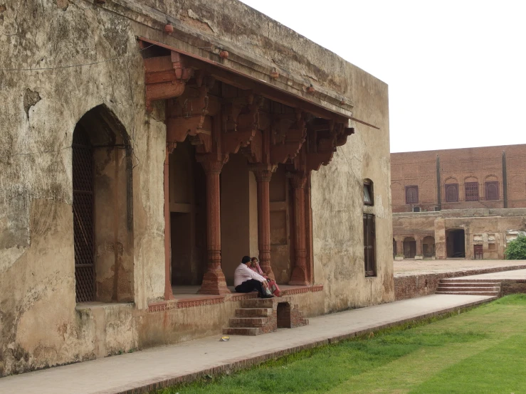 an older man sitting on top of a red step