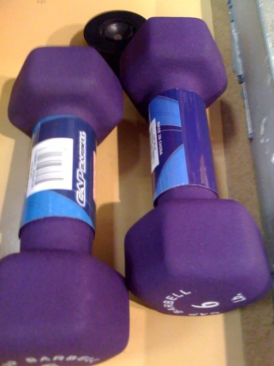 two purple dumbbells sit on top of a yellow table