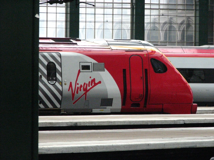 two trains are parked on the tracks next to each other