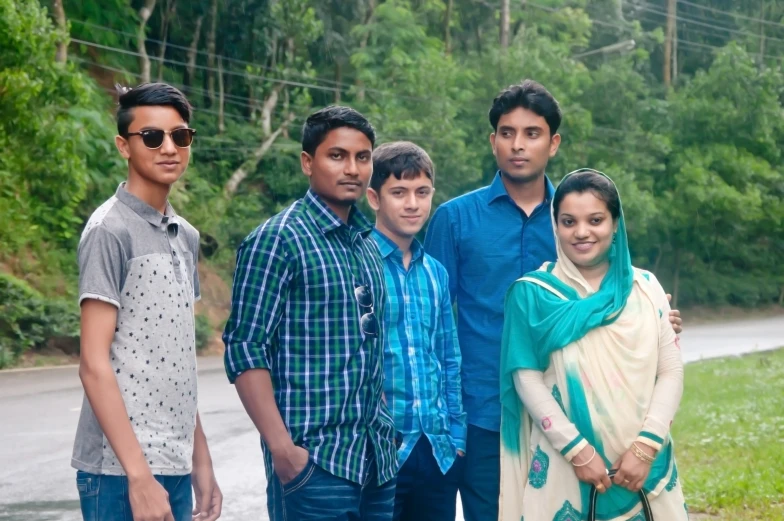 a group of young men and women posing for a picture on a road