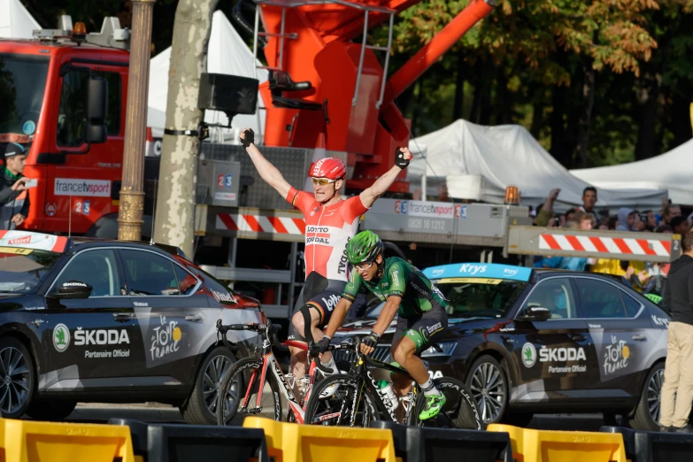 a cyclist and another person are riding their bikes in front of a group of cars