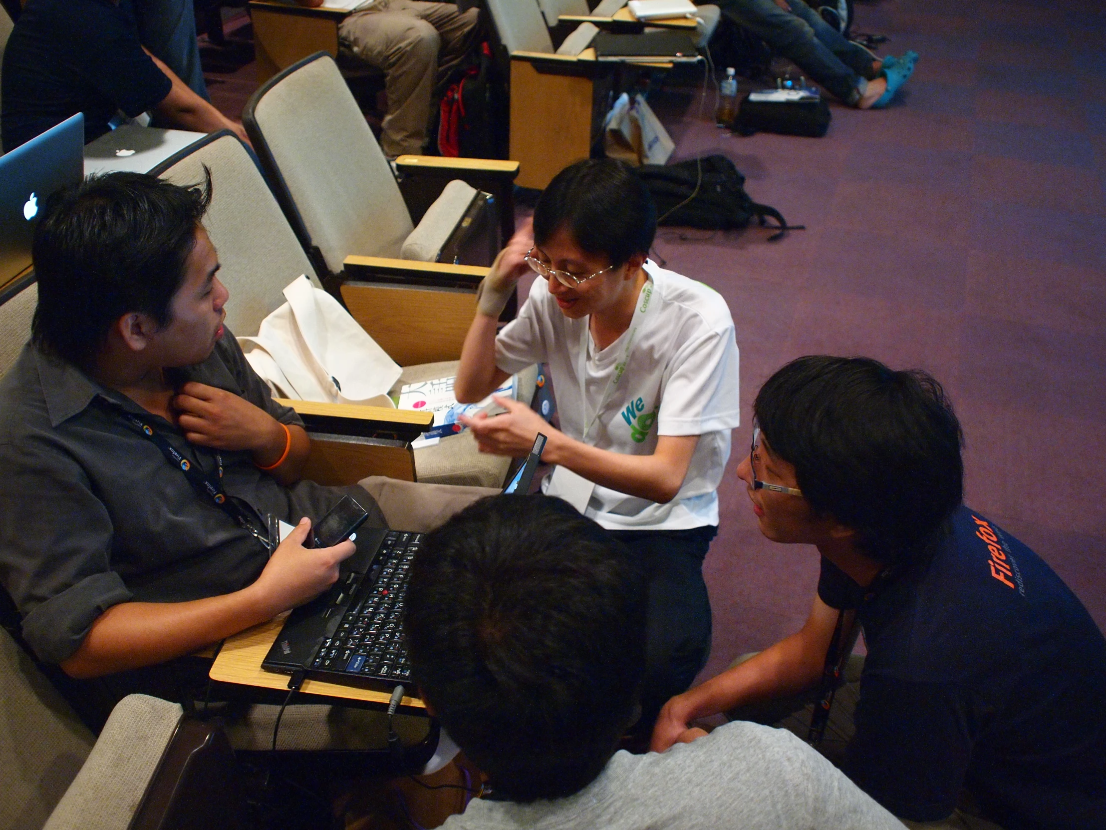 a group of people in auditorium seating looking at computers