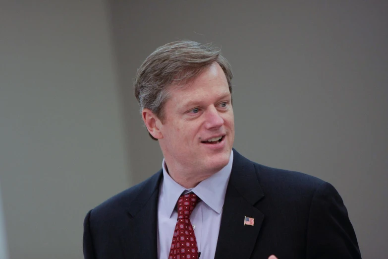 a man wearing a tie talking to the crowd