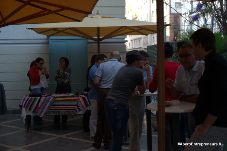 a group of people standing around talking and eating