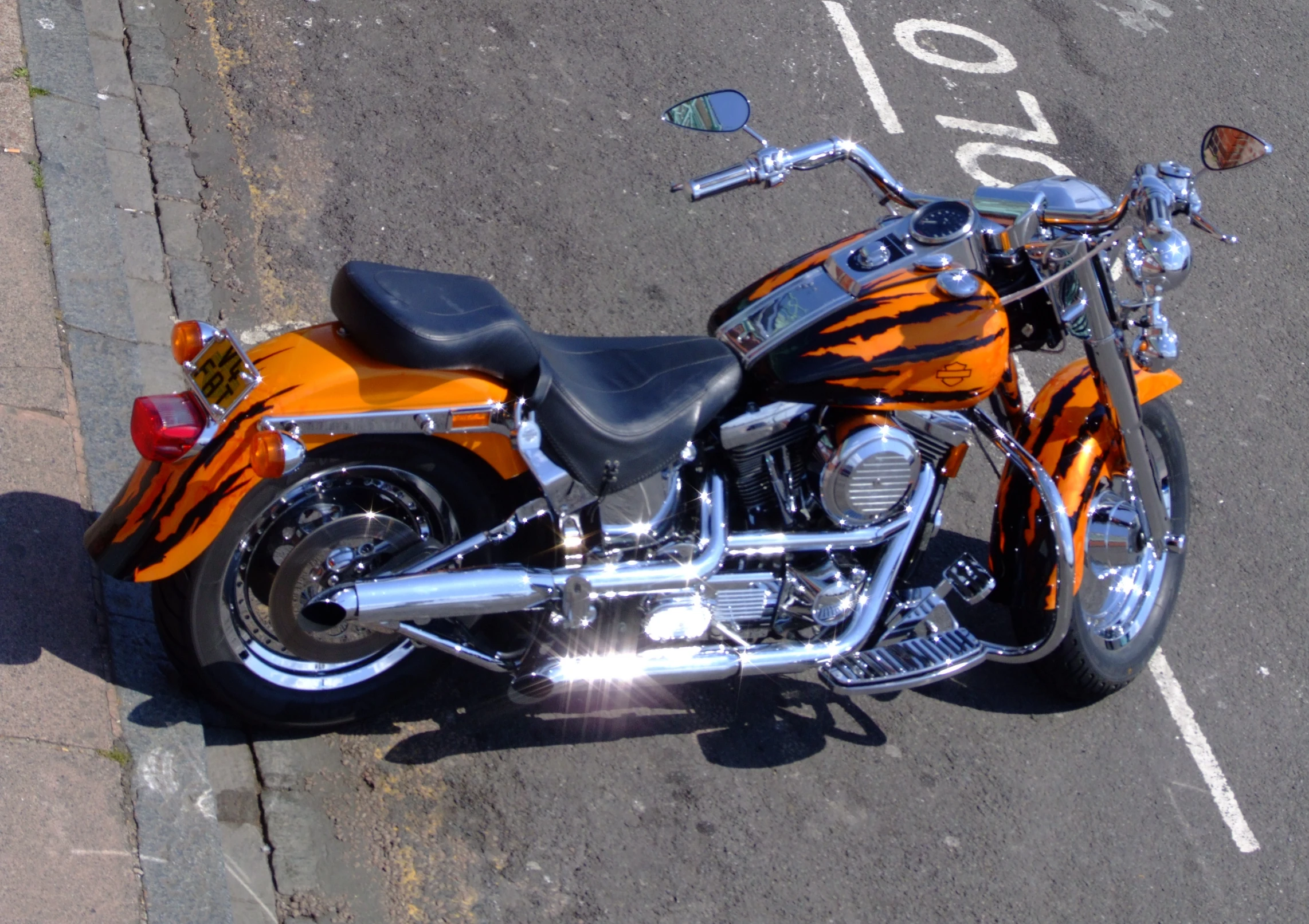 an orange motorcycle is parked on the side of the road