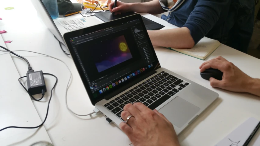 a group of people are working on laptops