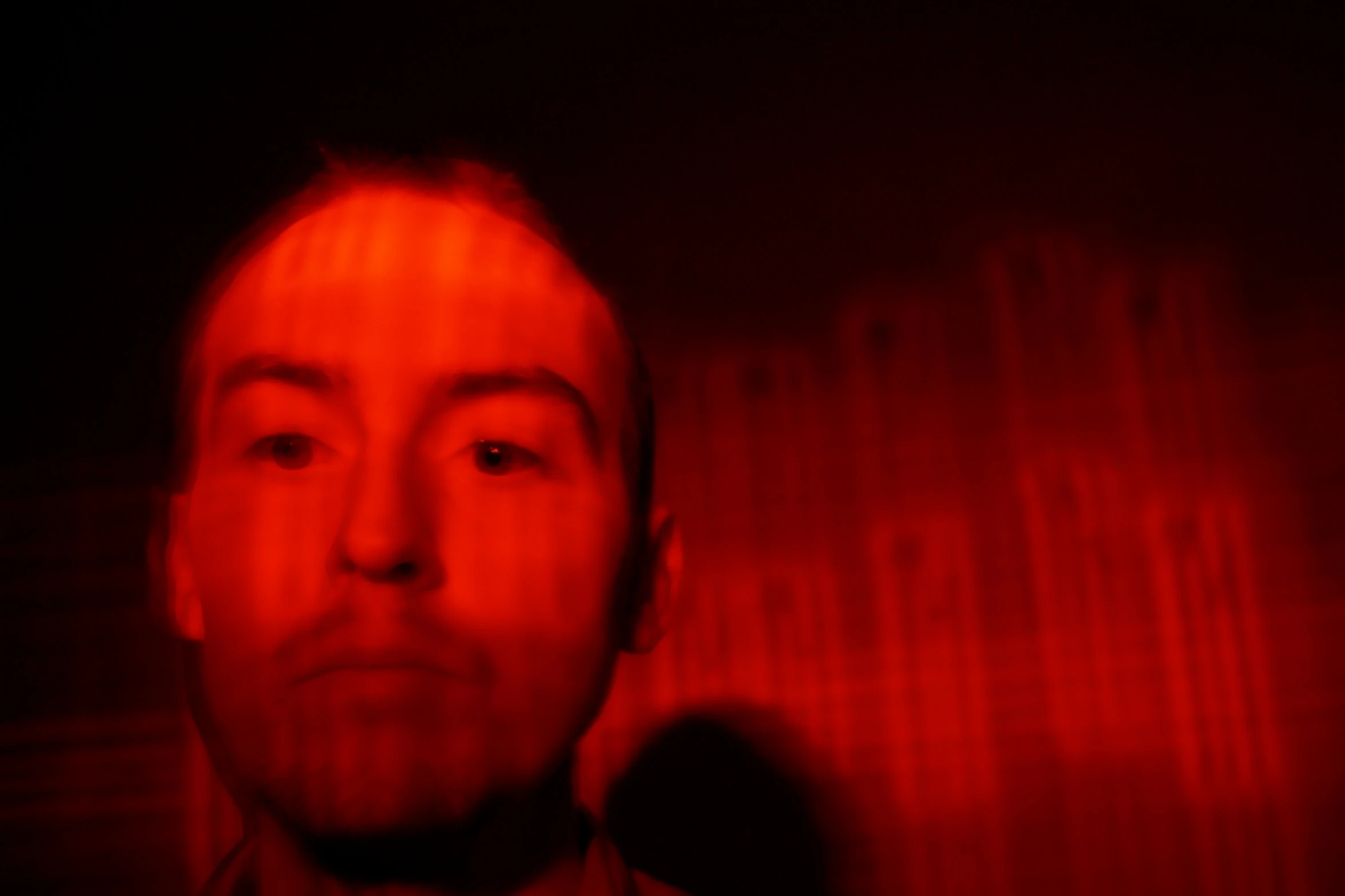 a man standing in front of a red light