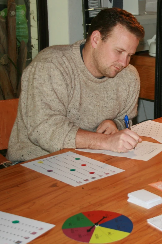 a man writing soing on a sheet of paper