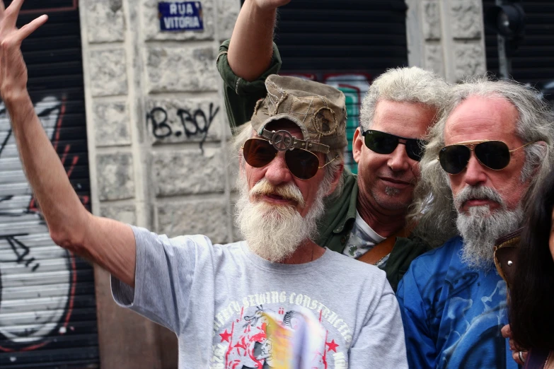 group of people with glasses waving near a building