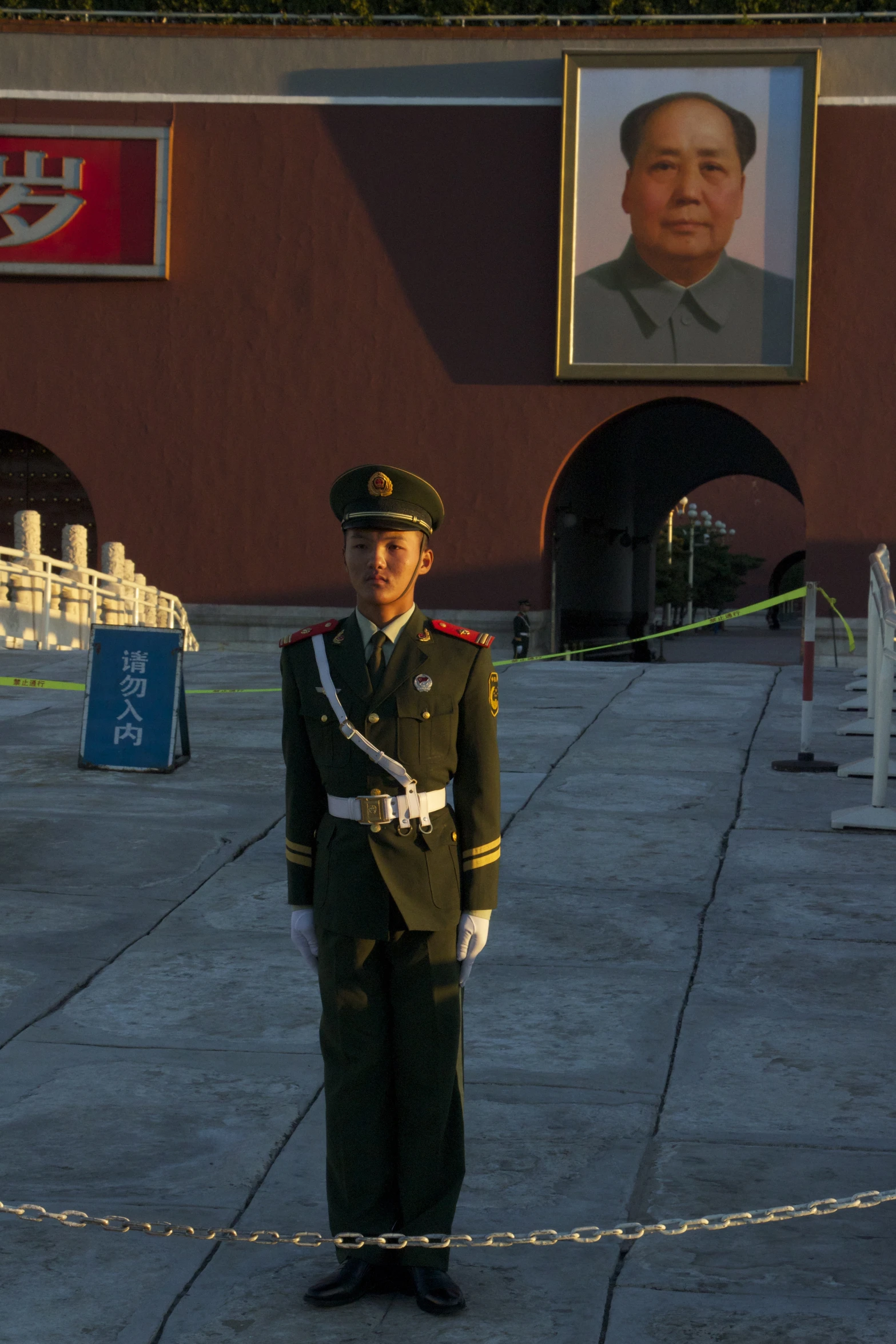 an uniformed soldier standing near a building and a picture