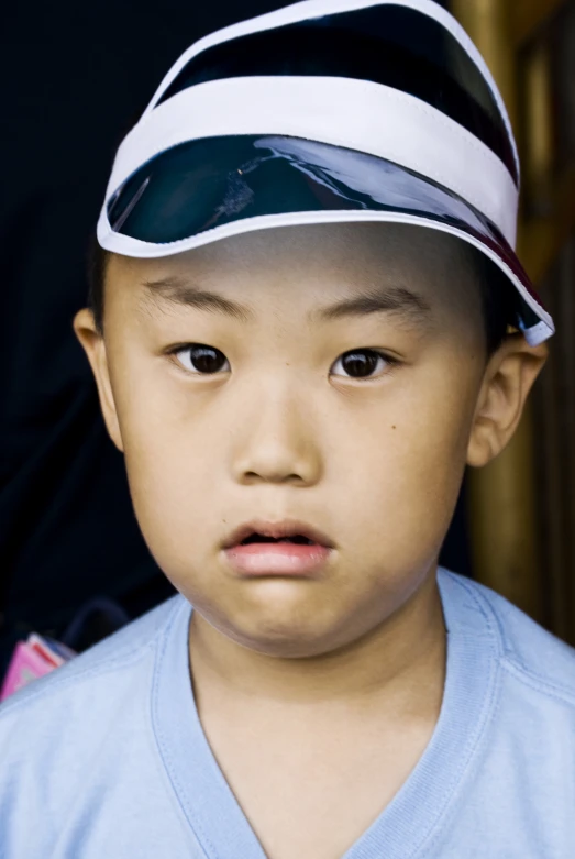 a young child is wearing a hat with the same color as his head