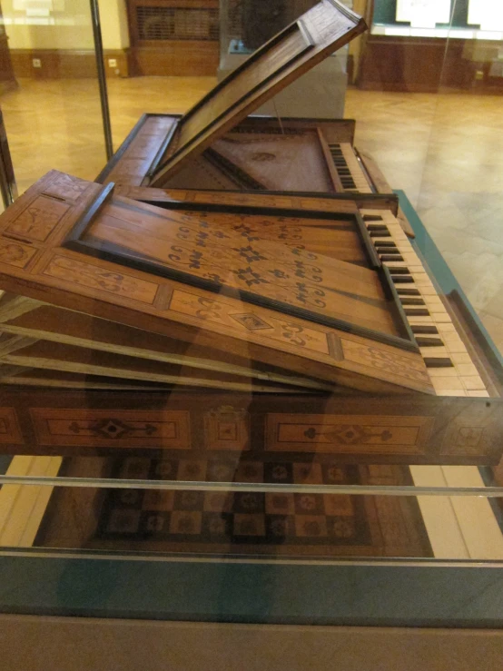 an antique piano is on display in a glass case