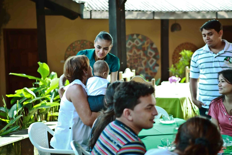 a group of people sitting around a table eating at a restaurant