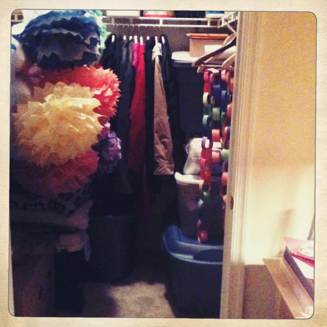 an open closet filled with a variety of sweaters