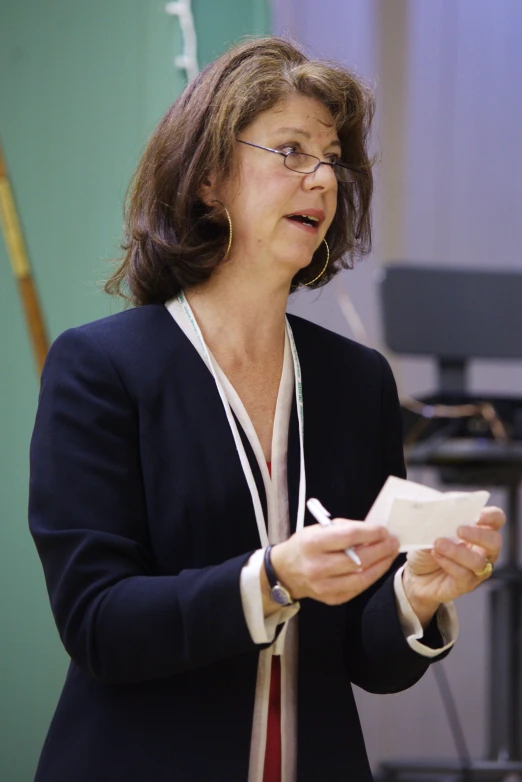 woman speaking with microphone and music equipment behind her