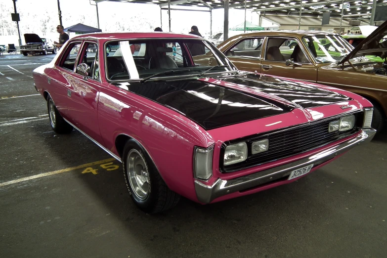 an old car has been painted pink and black