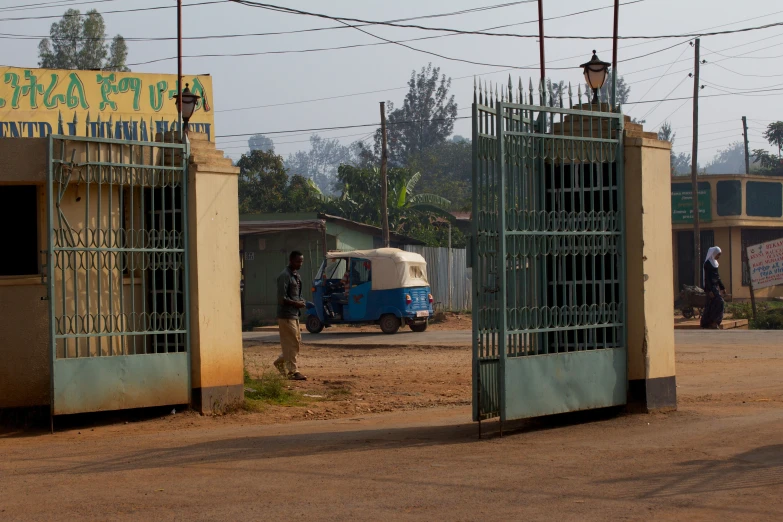 some buildings are connected with gates and a little guy is standing near them