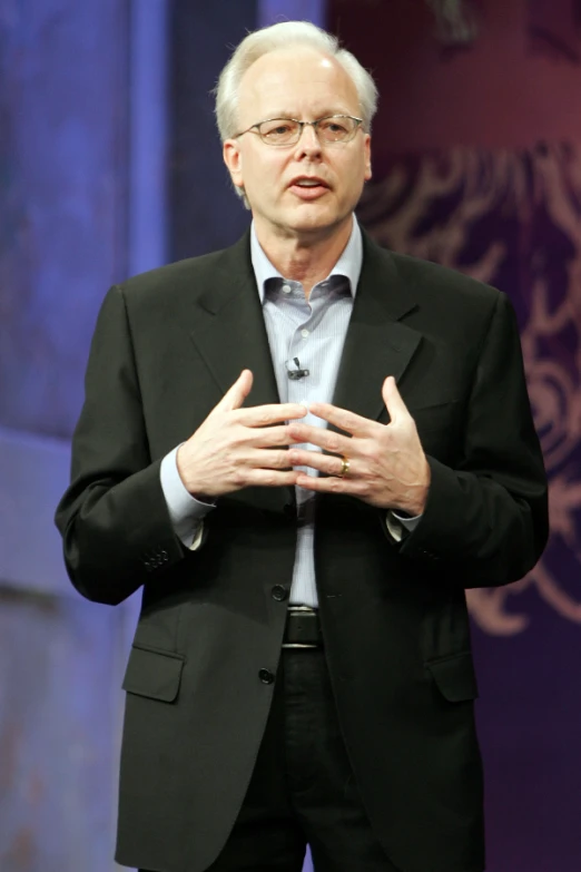 an older man wearing glasses is giving a talk