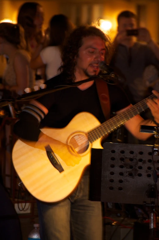 a man that is holding a guitar in his hand