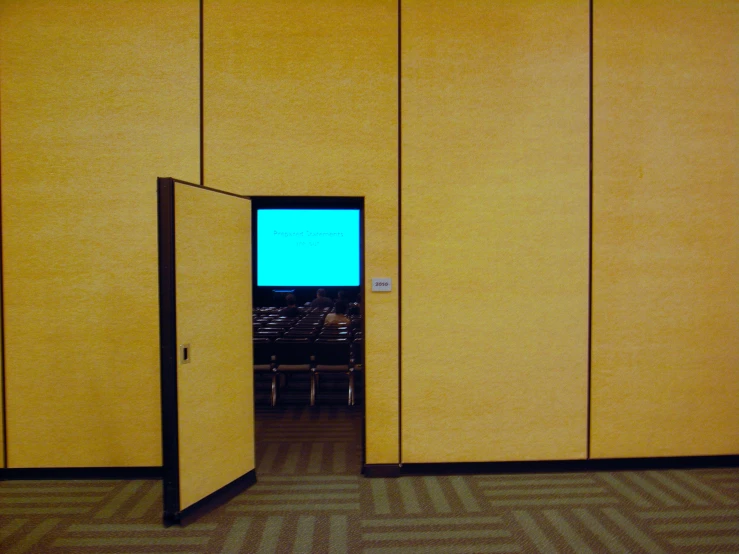 an empty room with a television screen sitting on the wall