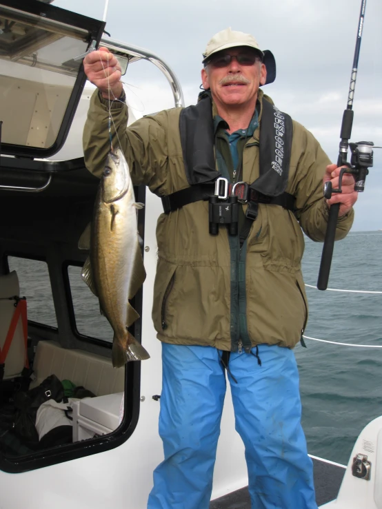 a man in his fishing gear and hat with a fish