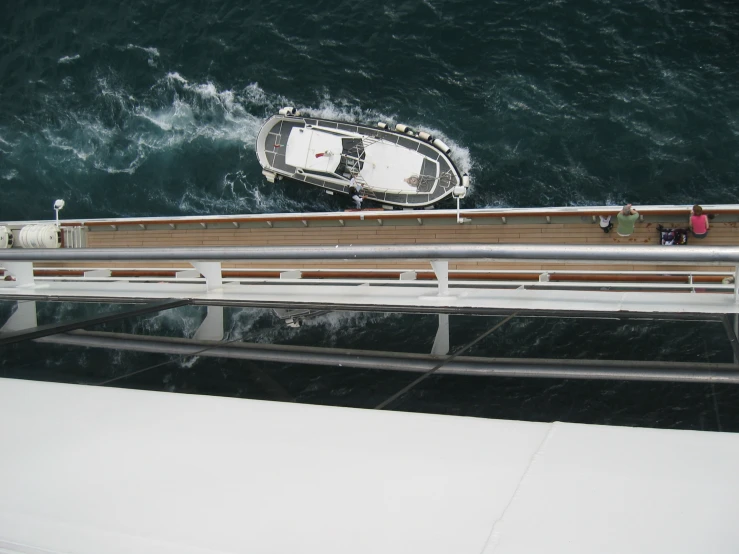 a boat floating on top of the ocean next to a pier