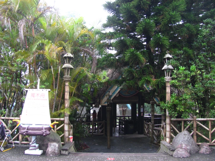 a park with a wooden gazebo and palm trees