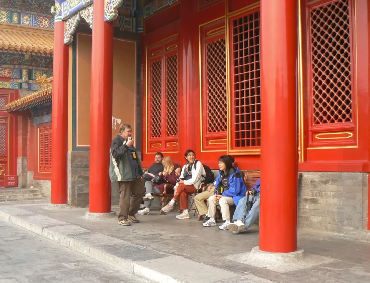 a group of people sitting in front of a building