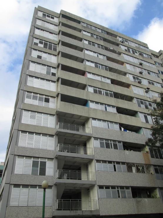 the exterior of a multi - story building with balconies on top and windows