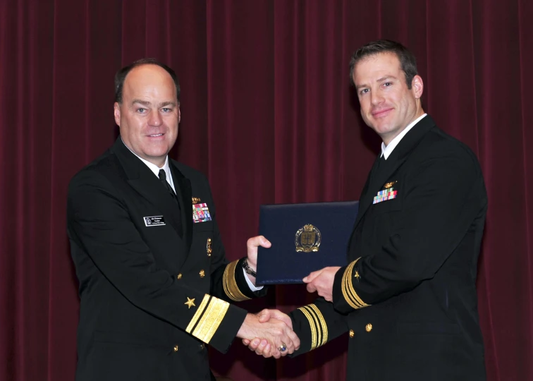 a man in a uniform shaking hands with another man