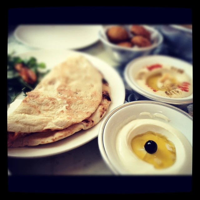 some plates with food on them including an egg and meat sandwich