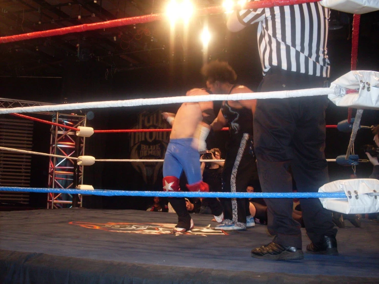 two men standing on a boxing ring in front of referee