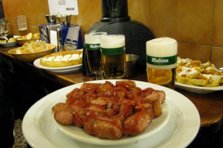 two white plates on a table with beers and pastries