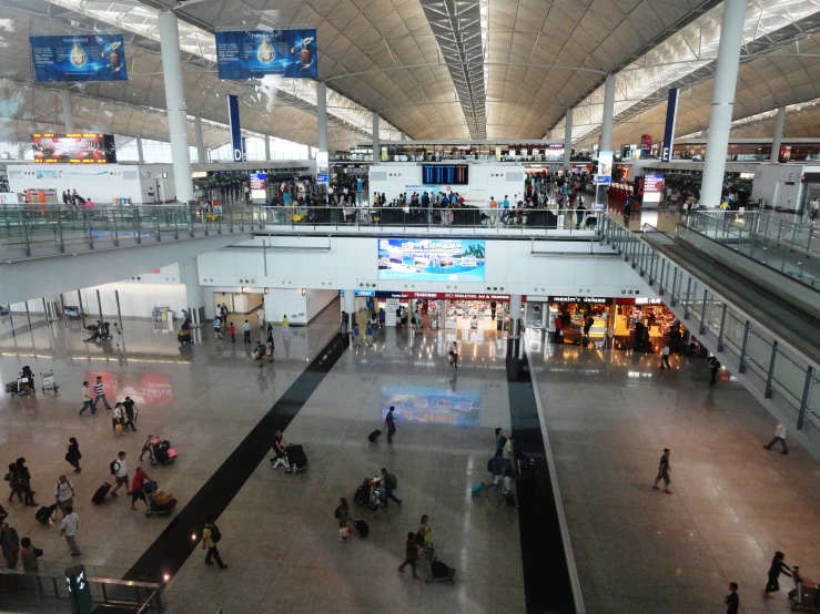 there are several people in the airport and one person is walking across the walkway