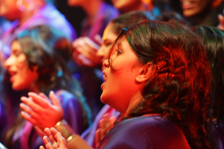 a group of women standing next to each other while clapping