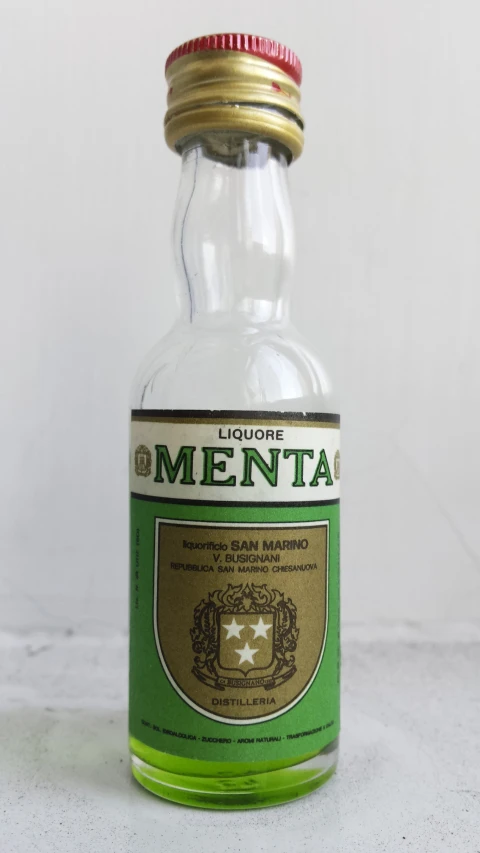 a green bottle of alcohol with gold cap