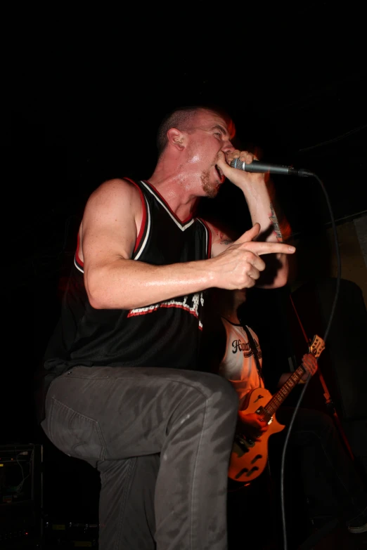 a man standing on top of a stool with a microphone