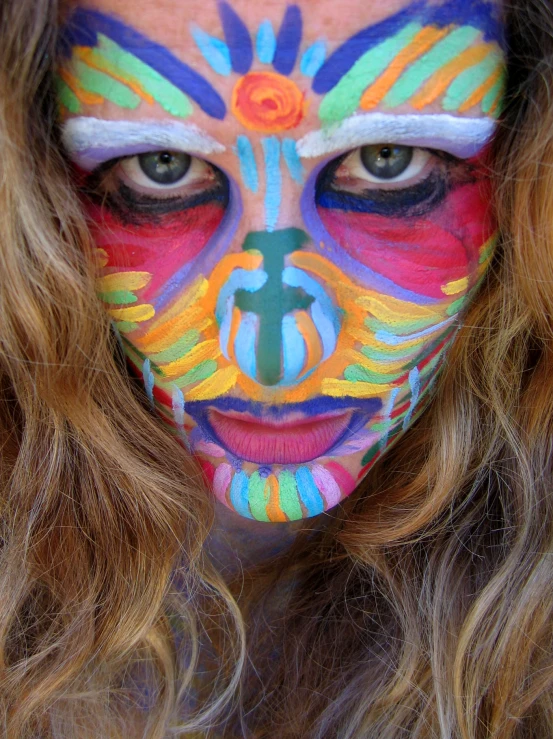 a girl with her face painted in bright colors