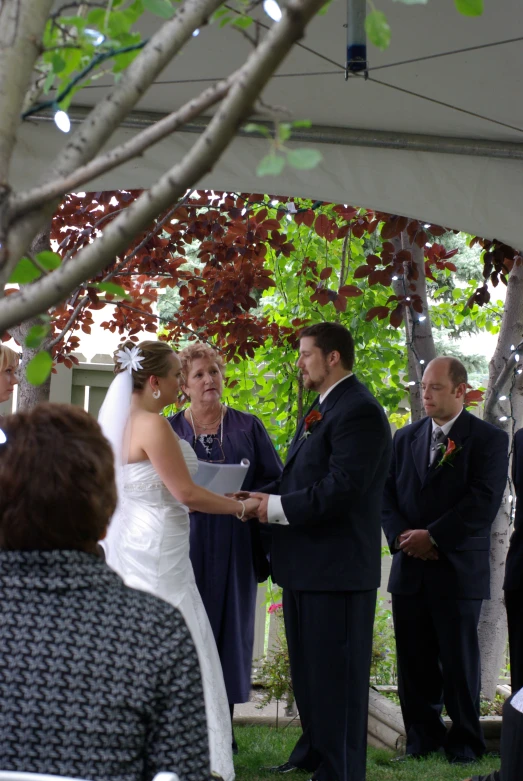 a bride and groom at a ceremony in a gazebo