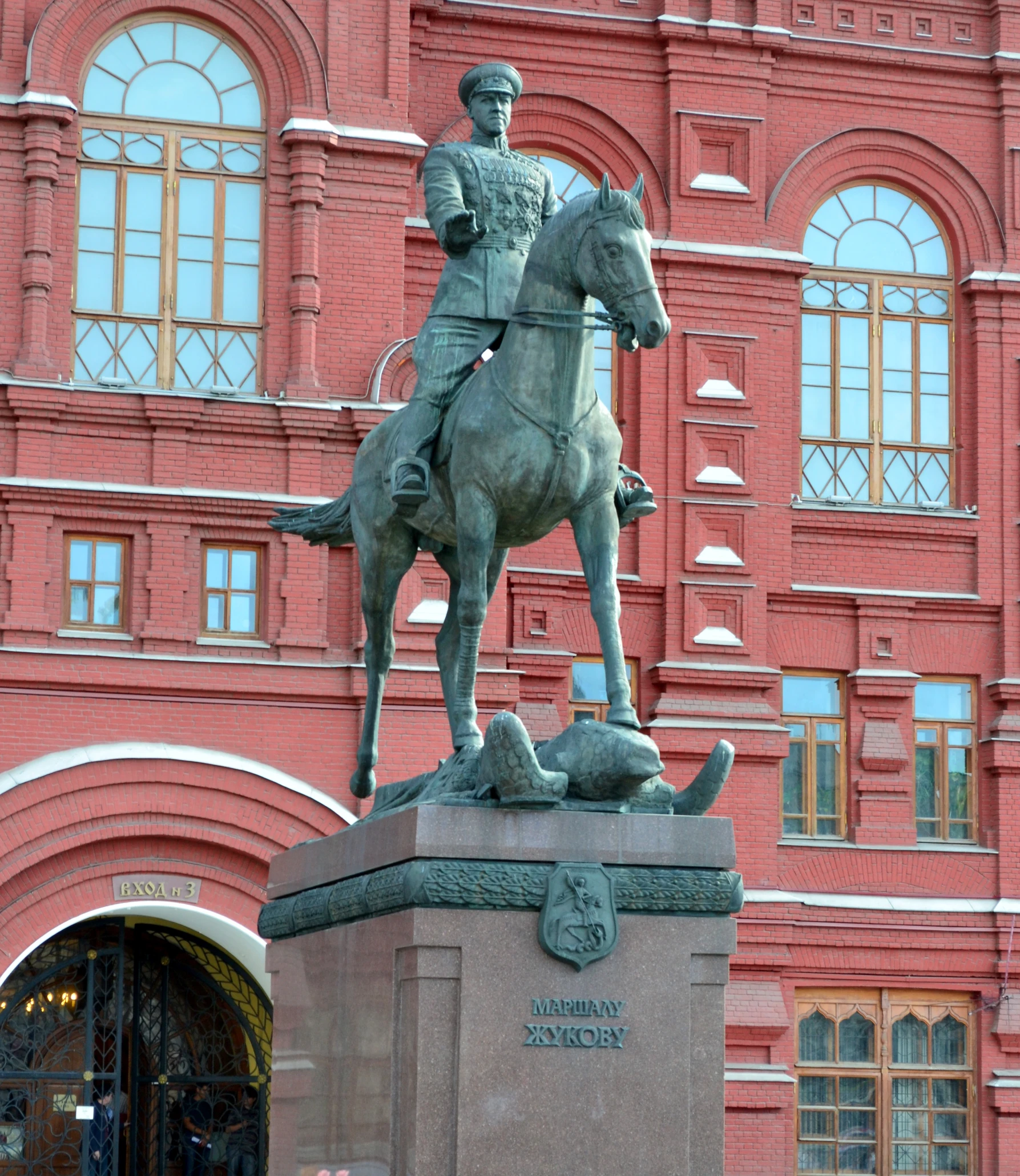 the statue of a man on a horse near a building