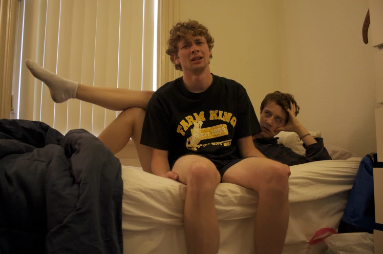 a couple of people sitting on top of a bed together