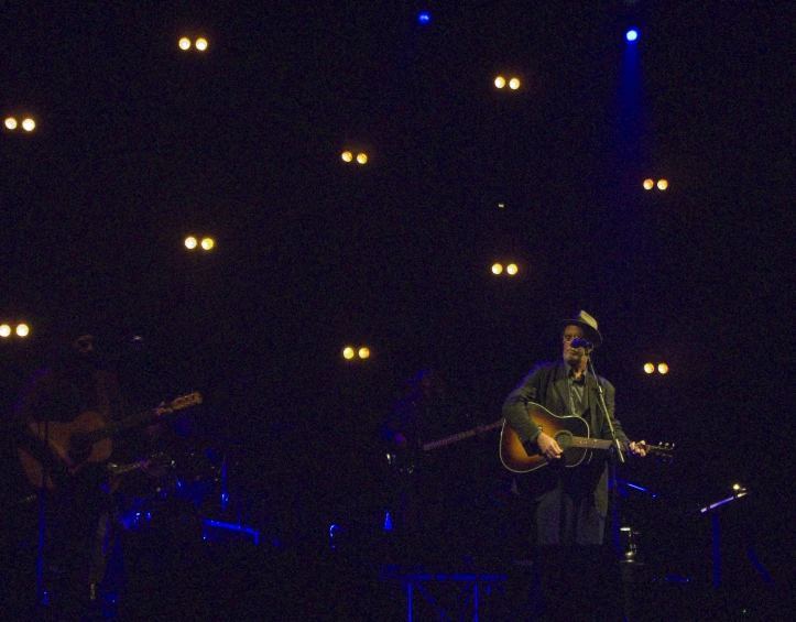 a man is playing guitar with blue lights