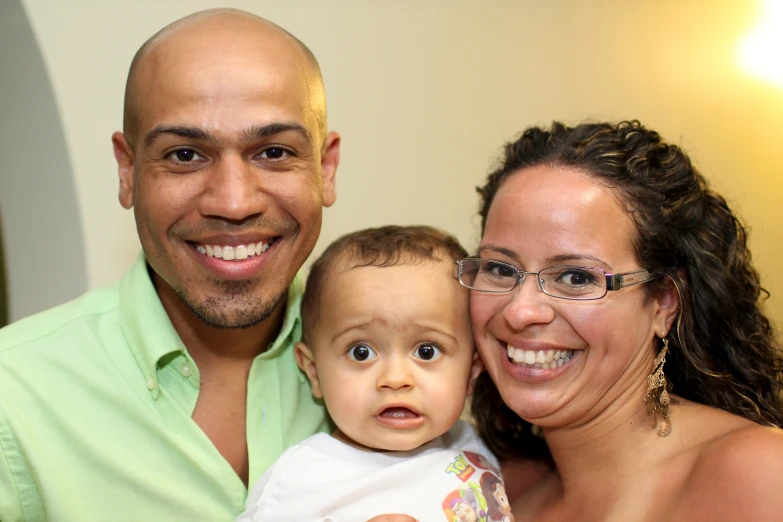 a man and woman pose with a baby