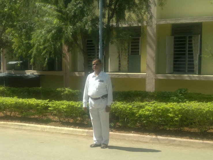 a man in white standing on a street