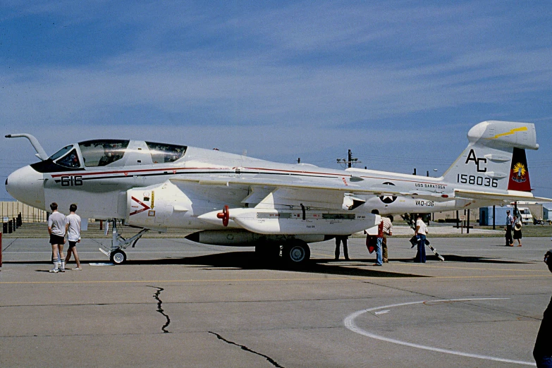 several people are walking towards an old model plane