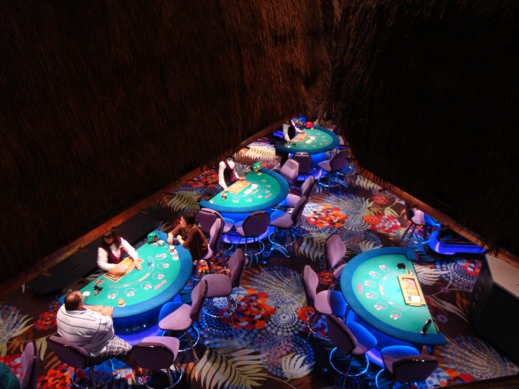 a casino table covered in blue velvet and a person sitting at the table