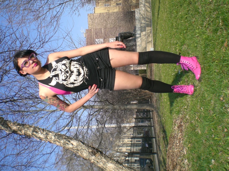 a girl posing with her hand on her hip in pink high - top sneakers