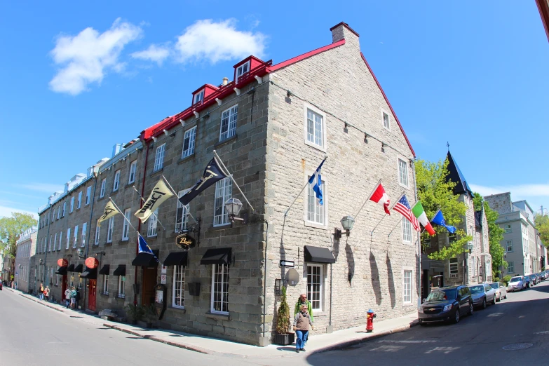 there is a building with several windows and flags on it